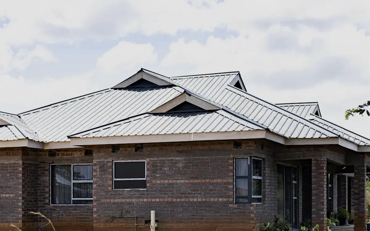 Grey standing seam metal roof on a modern brick bungalow
